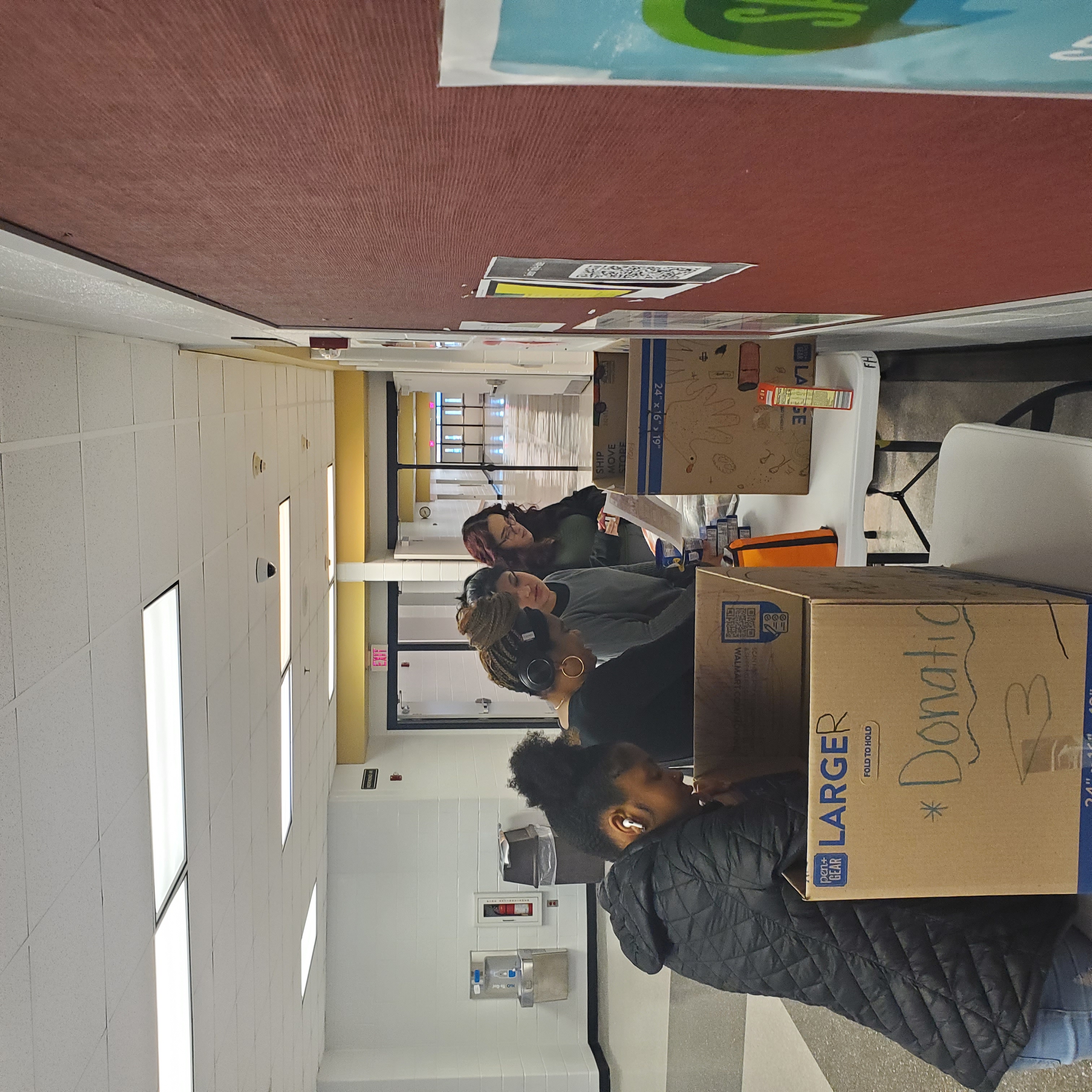 students standing in front of a table with large boxes sorting items