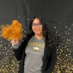 Ms. Arriaza-Chavez shaking a pom pom