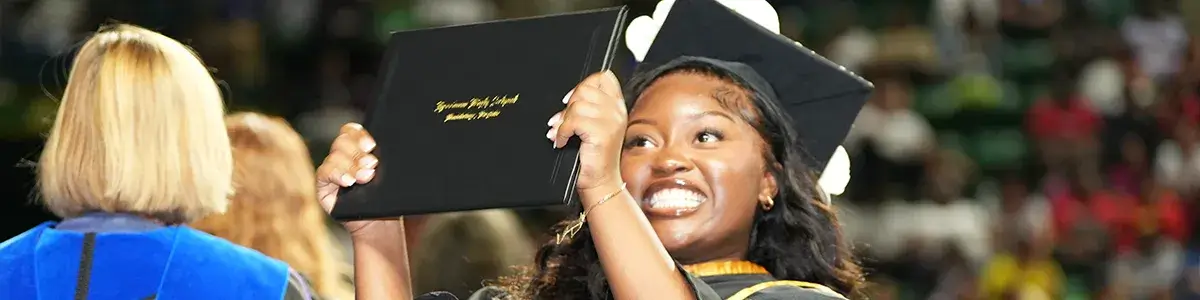 Freedom High School student holding up her diploma at the 2024 graduation ceremony