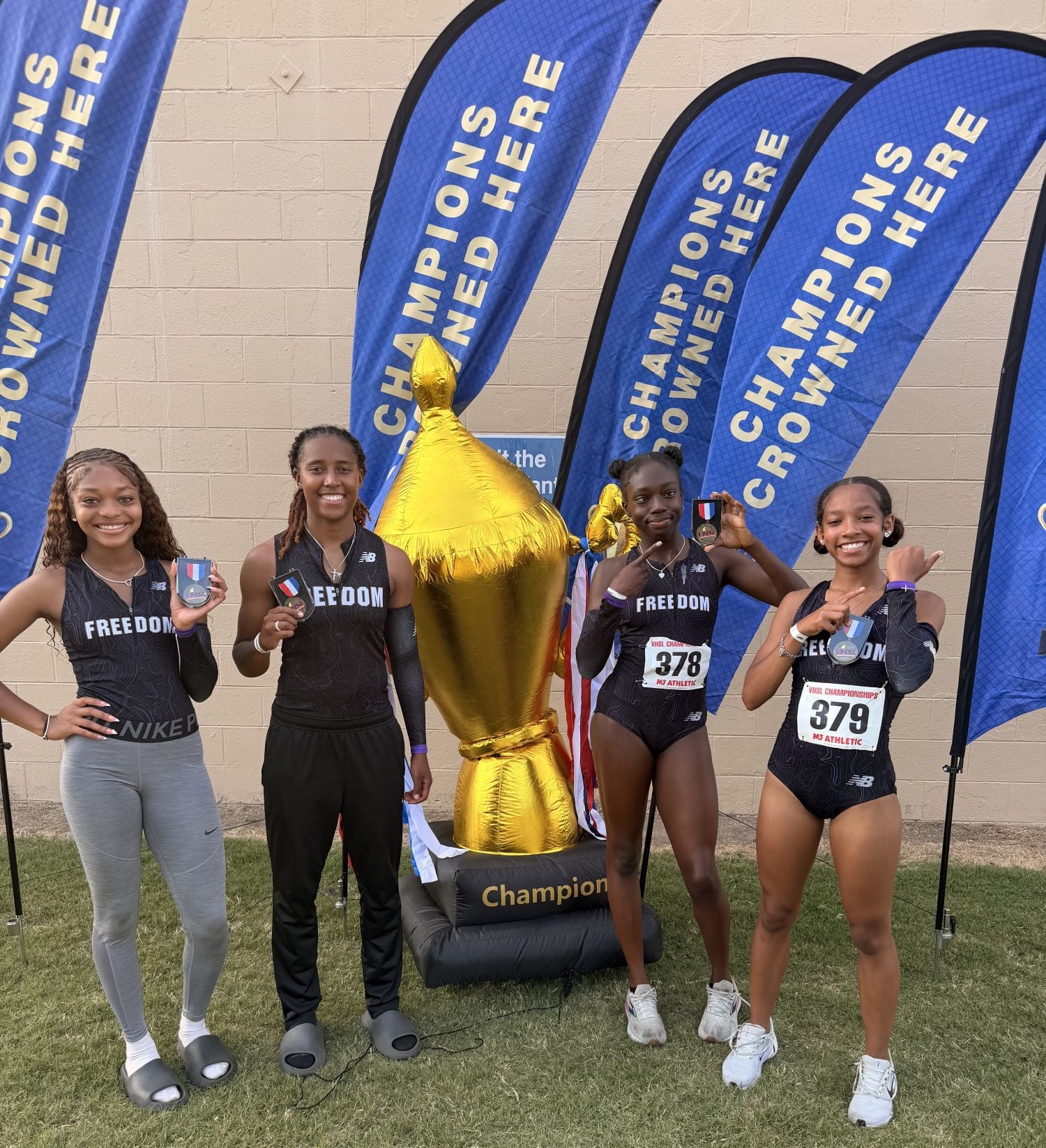 picture of girls track 4 by 400 team holding medals